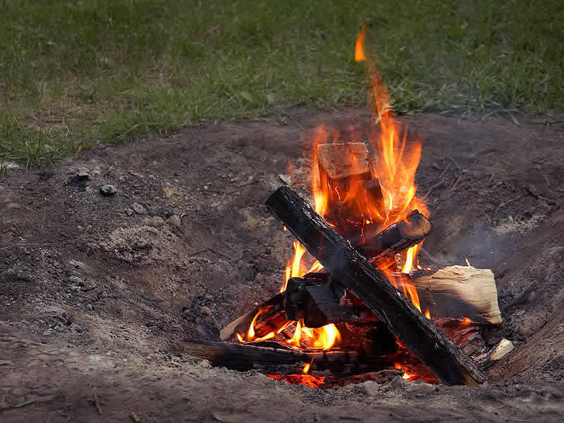 Small fire in backyard fire pit - travel - camping danger