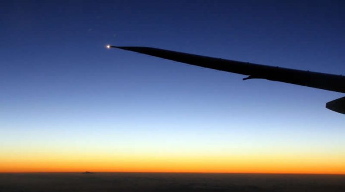 Travel photo - plane wing in the air - moon and mercury during sunset